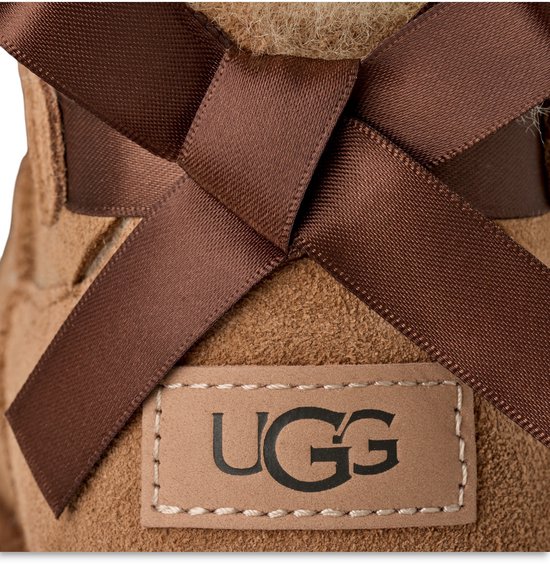 Bruine suède UGG laars met bruine satijnen strik en UGG logo label.