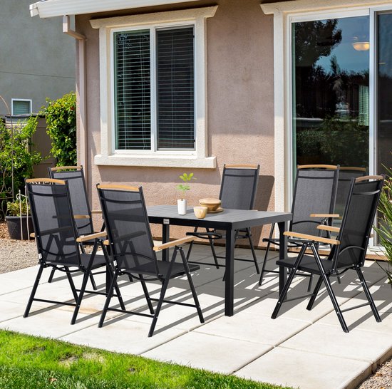 Zwarte tuinset met tafel en zes stoelen op een terras.