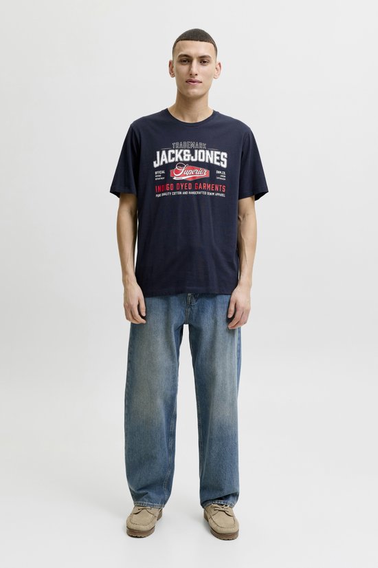 Man met Jack & Jones logo op donkerblauw T-shirt en spijkerbroek.