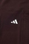 Bruine legging met wit Adidas-logo op de heup.