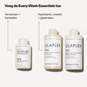 Olaplex N°3 Haar Perfector, N°4 Shampoo en N°5 Conditioner in witte flessen met beige accenten.