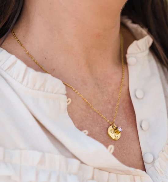 Chaîne dorée avec pendentif gravé d'une pivoine et d'une pierre violette.