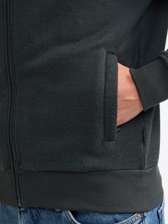 Close-up van de zak van een donkergroen vest met rits.