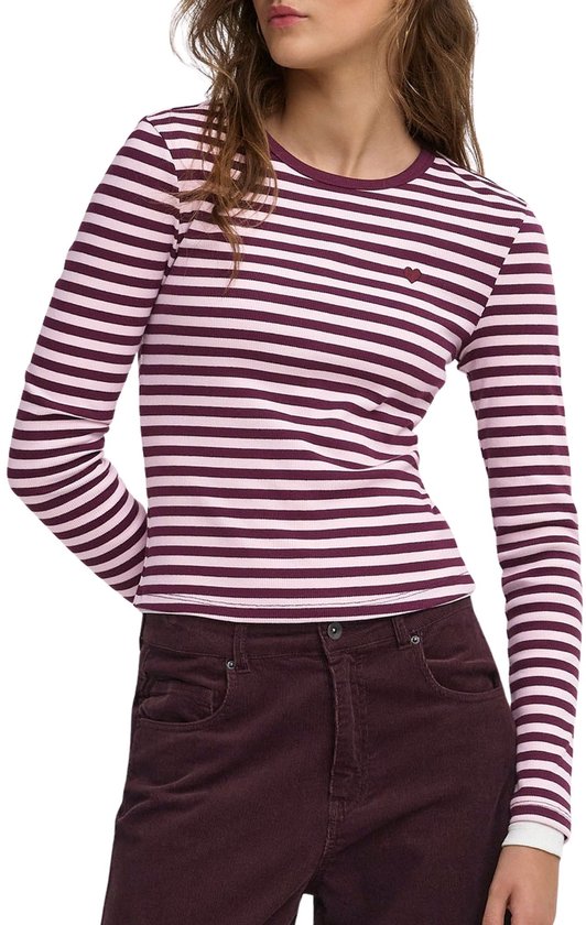 T-shirt rayé violet et blanc à manches longues avec un petit cœur brodé, porté avec un pantalon violet foncé.