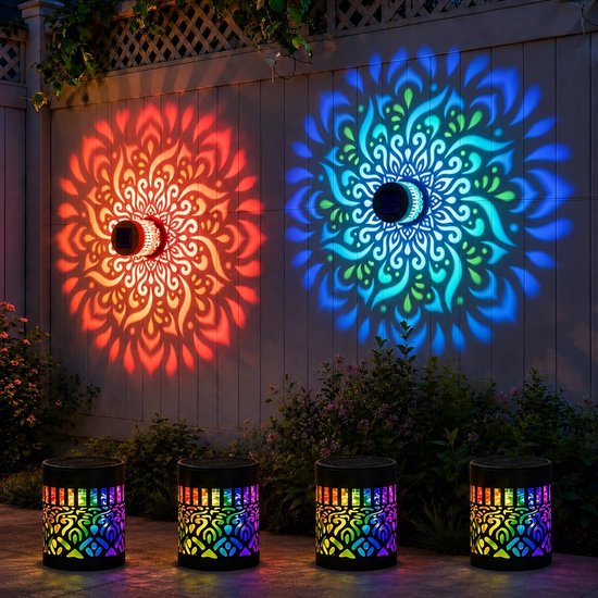 Twee zwarte zonne-wandlampen projecteren rode en blauwe mandala-patronen op een houten schutting. Vier cilindrische lampen met regenboogkleurige patronen staan op de grond.