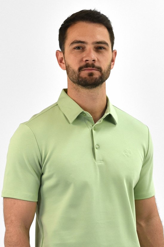 Close-up van een man in een lichtgroene Vercate polo met korte mouwen.