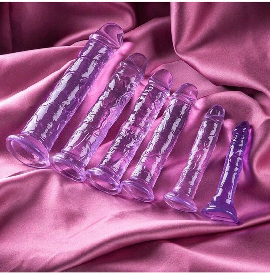 Een rij van zes paarse, doorschijnende, getextureerde dildo's van oplopende grootte op een roze satijnen achtergrond.