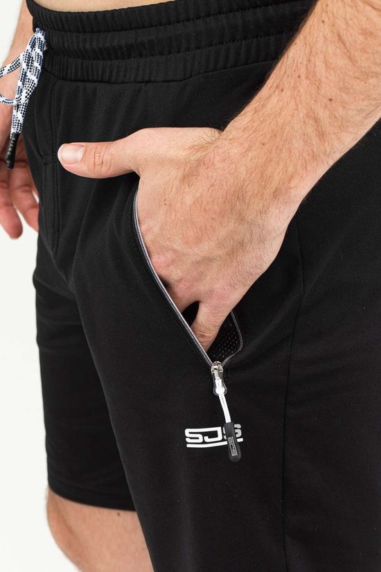 Gedetailleerde close-up van een zwarte korte sportbroek met ritsvak en logo.