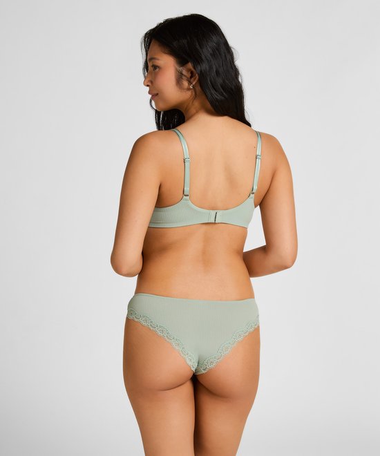 Achterkant van een vrouw in mintgroene rib-slip met kanten randje.