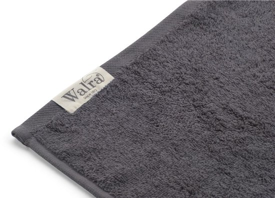 Gros plan d'une serviette grise unie avec un ourlet tissé et l'étiquette Walra.