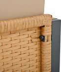 Detail van de hoek van een beige stoel met bruin rotan vlechtwerk en een grijs metalen frame.