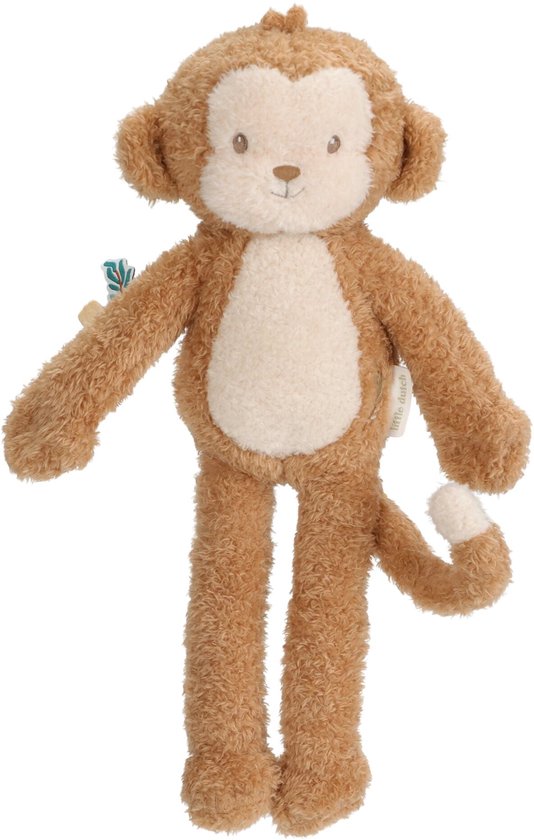Doudou singe marron avec ventre et oreilles clairs, debout avec une étiquette sur le côté.