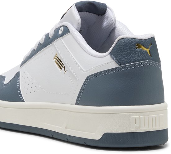Gedetailleerde Puma Court Classic sneaker in wit met blauw, gouden Puma-logo op de hiel.