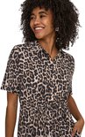 Close-up van een dame in een jurk met luipaardprint, korte mouwen, strikceintuur en kraagje.