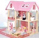 Roze poppenhuis met houten details. Een keramische pop in dienstbodekostuum staat in de woonkamer.