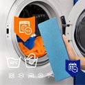 Blauw dweildoek in een hand, naast een wasmachine met wasgoed.