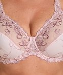 Close-up van de cups van een lichtroze beugel bh met fijne bloemenbroderie en kanten afwerking.