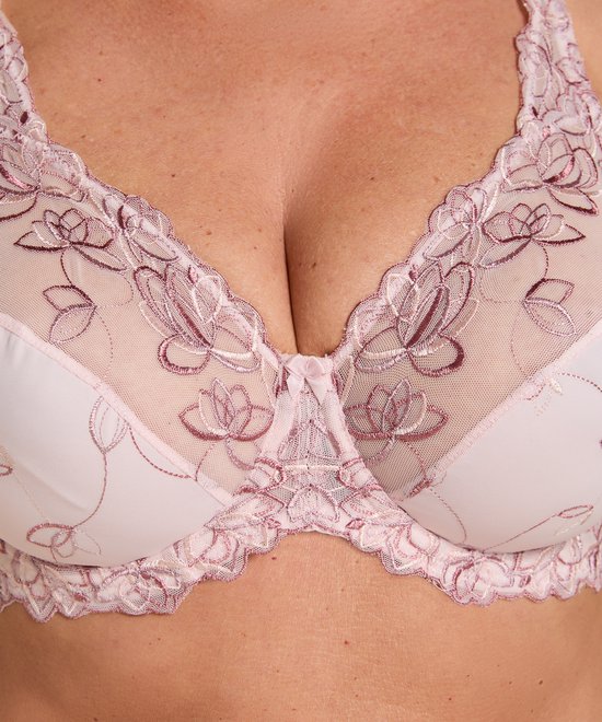 Close-up van de cups van een lichtroze beugel bh met fijne bloemenbroderie en kanten afwerking.