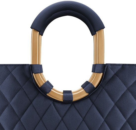 Goudkleurig frame met donkerblauwe ribbels als handvat boven een donkerblauwe shopper met ruitpatroon.