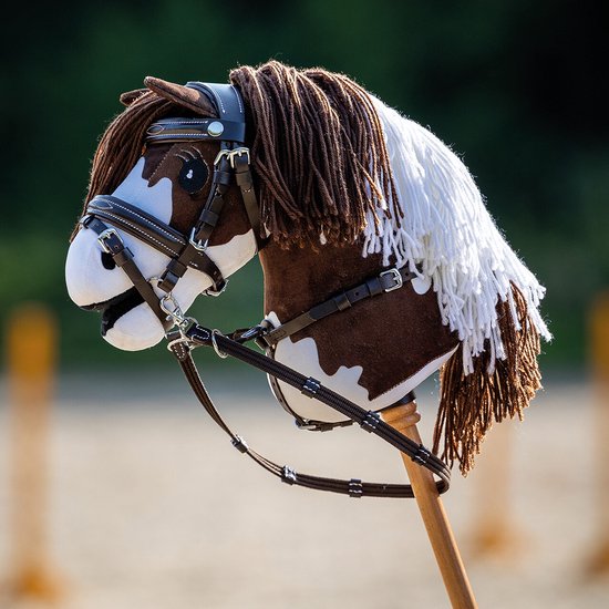 Bruin-witte hobbyhorse met bruine manen en witte strengen, inclusief hoofdstel.