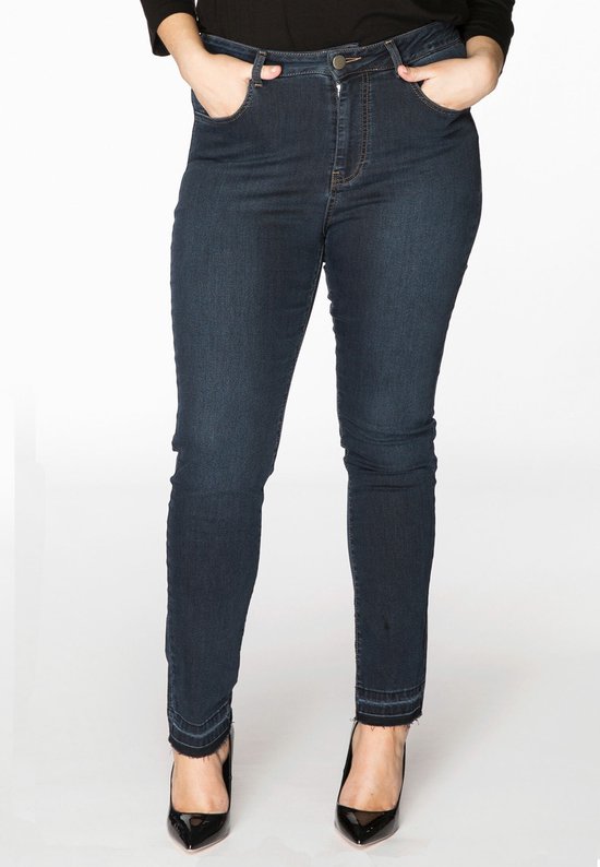 Donkerblauwe spijkerbroek met hoge taille, rafelige zoom en zwarte hakken.