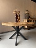 Table à manger ronde en bois avec pied Matrix noir, décorée de vases.
