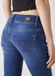 Close-up van de achterkant van een donkerblauwe jeans met LTB-label en oranje stiksels.