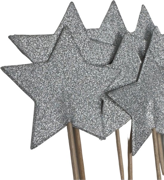 Zilveren glitterster cocktailprikkers op zwarte achtergrond.