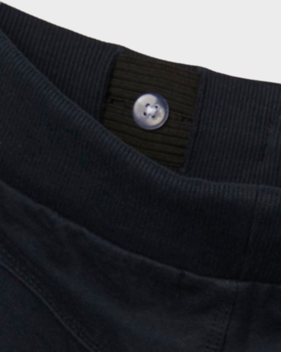 Detail van een donkerblauwe tailleband met een knoopsluiting en elastische band.