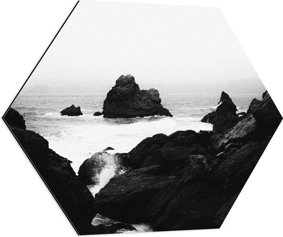 WallClassics - Dibond Hexagon - Golven tegen hoge Rotsen in het Water (Zwart- wit) - 70x60.9 cm Foto op Hexagon (Met Ophangsysteem)