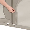 Close-up van een hand die de ritssluiting van een beige box sluit.