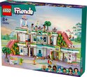 Centre commercial LEGO Friends Heartlake City 42604, un bâtiment à trois niveaux avec des toboggans roses, de nombreuses fenêtres et des mini-poupées.