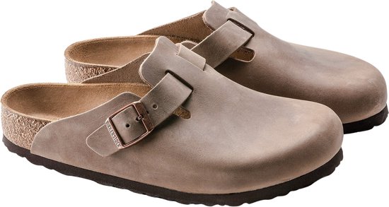 Paar bruine Birkenstock Boston slippers met koperkleurige gespen en suède afwerking.