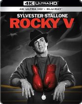 Sylvester Stallone als Rocky in "Rocky V", met rode bokshandschoenen om zijn nek en een hoed.
