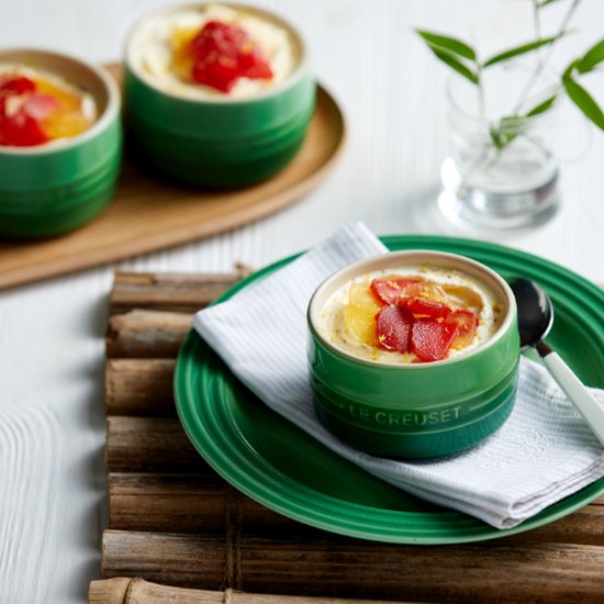 Groene Le Creuset ramekins gevuld met dessert en fruit.
