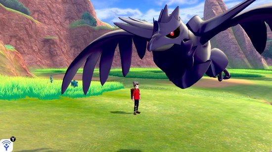Zwarte vogel Pokémon met rode ogen vliegt boven een jongen met rode trui en bruine rugzak in een groen veld.