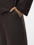 Detail van de donkerbruine pantalon, met zakken.