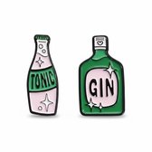 Twee emaille broches: een groene fles met 'GIN' en een lichtere fles met 'TONIC'.