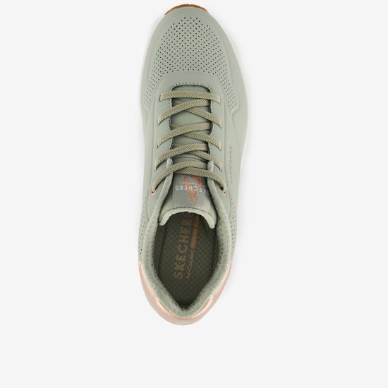 Bovenkant van een lichtgroene Skechers Uno sneaker met veters en gouden accenten.