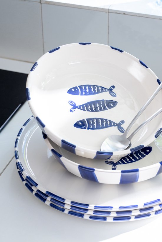 Wit keramiek met blauwe visdecoratie en blauwe strepen aan de rand. Drie blauwe visjes op de bodem van de schaal.