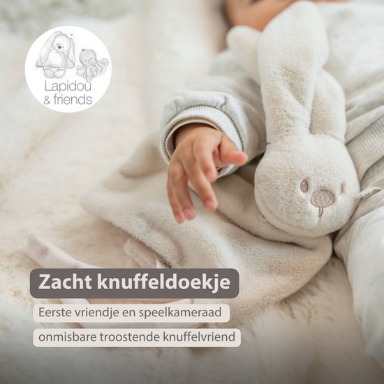 Crèmekleurig konijnen knuffeldoekje met zachte textuur, omhuld door een baby.