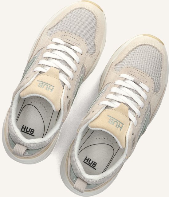 Paar beige suède en mesh sneakers met witte veters en HUB-logo op de tong.