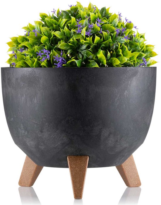 Zwarte ronde bloempot op houten poten, gevuld met groene plant en paarse bloemetjes.