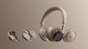 Gedemonteerde beige JBL koptelefoon met luidspreker, printplaat en batterij zichtbaar.