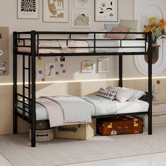 Zwart metalen stapelbed met beddengoed, kussens en een opbergkist eronder.