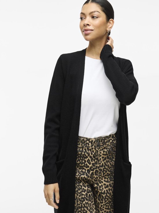 Zwarte gebreide vest met lange mouwen, gedragen door een model met luipaardprint broek.