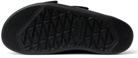Onderkant van een zwarte slipper met een profielzool en REEF logo.