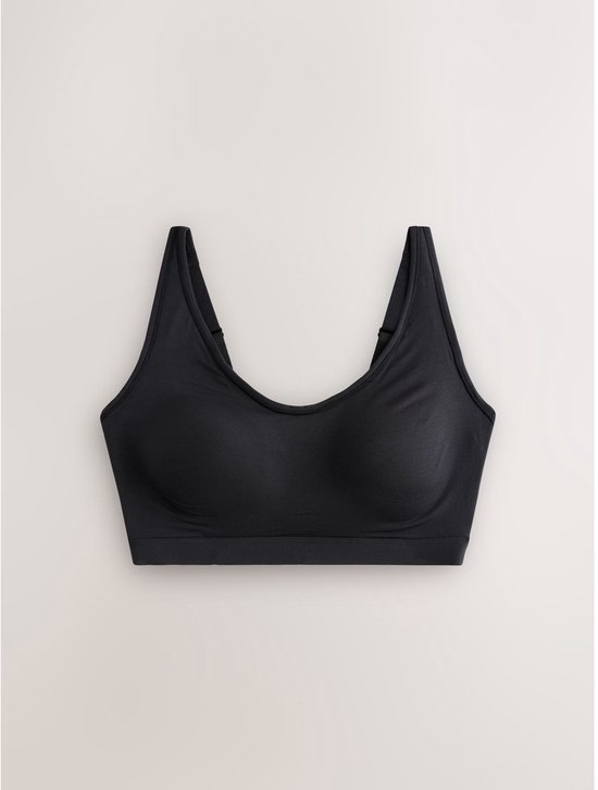 Zwarte crop top beha liggend op een witte achtergrond.