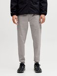 Grijze joggingbroek met strakke broekspijpen en 'JJ Athletic Dept.' opdruk, gedragen met zwarte sneakers.