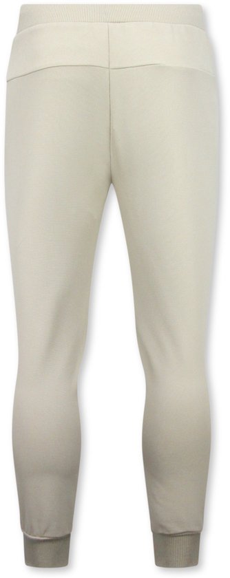 Beige joggingbroek met elastische tailleband en manchetten.